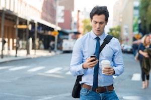 Man walking by a pedestrian crossing with the phone